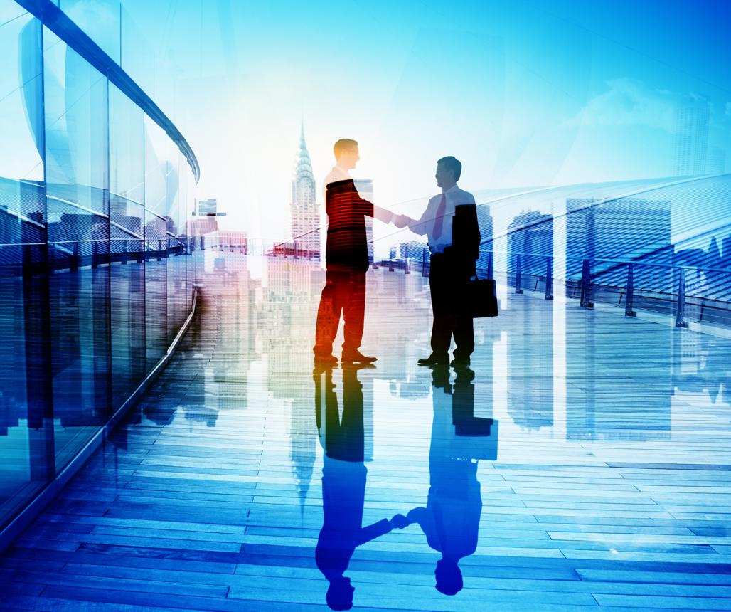 Two business partners shaking hands against a global city skyline